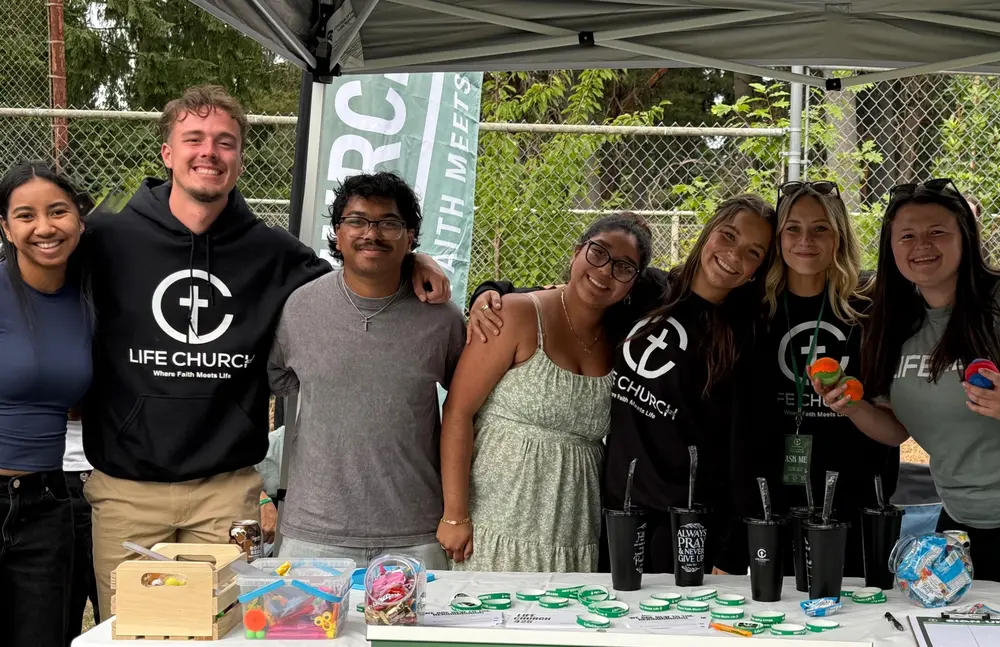 Life 425.Church volunteers gathered at a community event welcome table