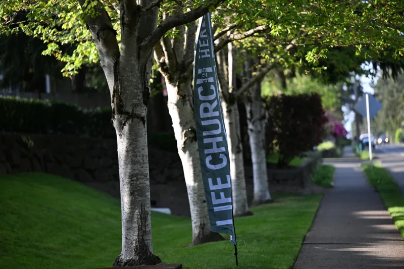 Life Church welcome banner beside a tree-lined sidewalk